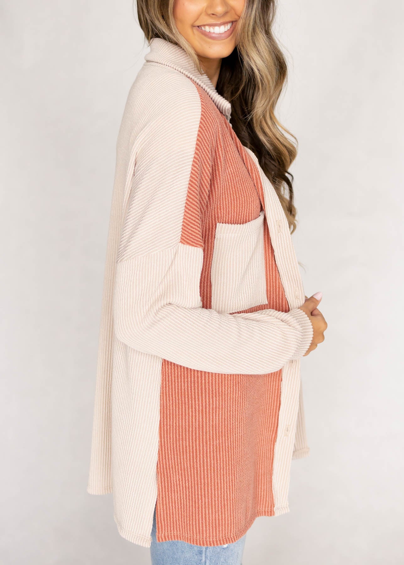 Side view of a cream shacket with a coral color block