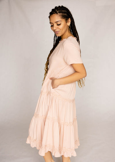 Side view of a blush dress with pockets