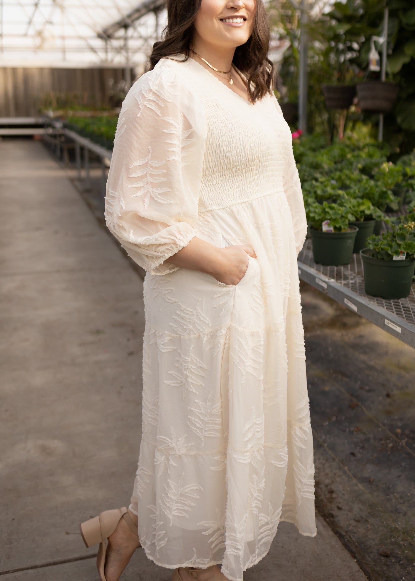 Side view of a plus size cream dress with pockets