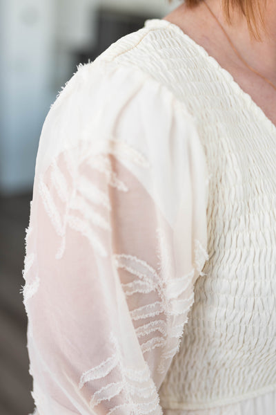 Sleeve of a cream dress