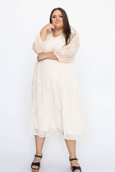 Plus size cream dress with sheer sleeves and smocked bodice