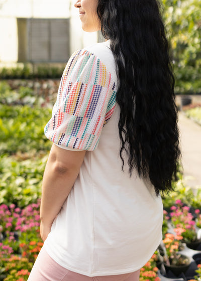 Side view of a white top with colorful sleeves