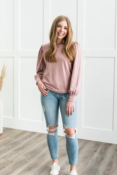 Long sleeve mauve top with a ruffle at the shoulder
