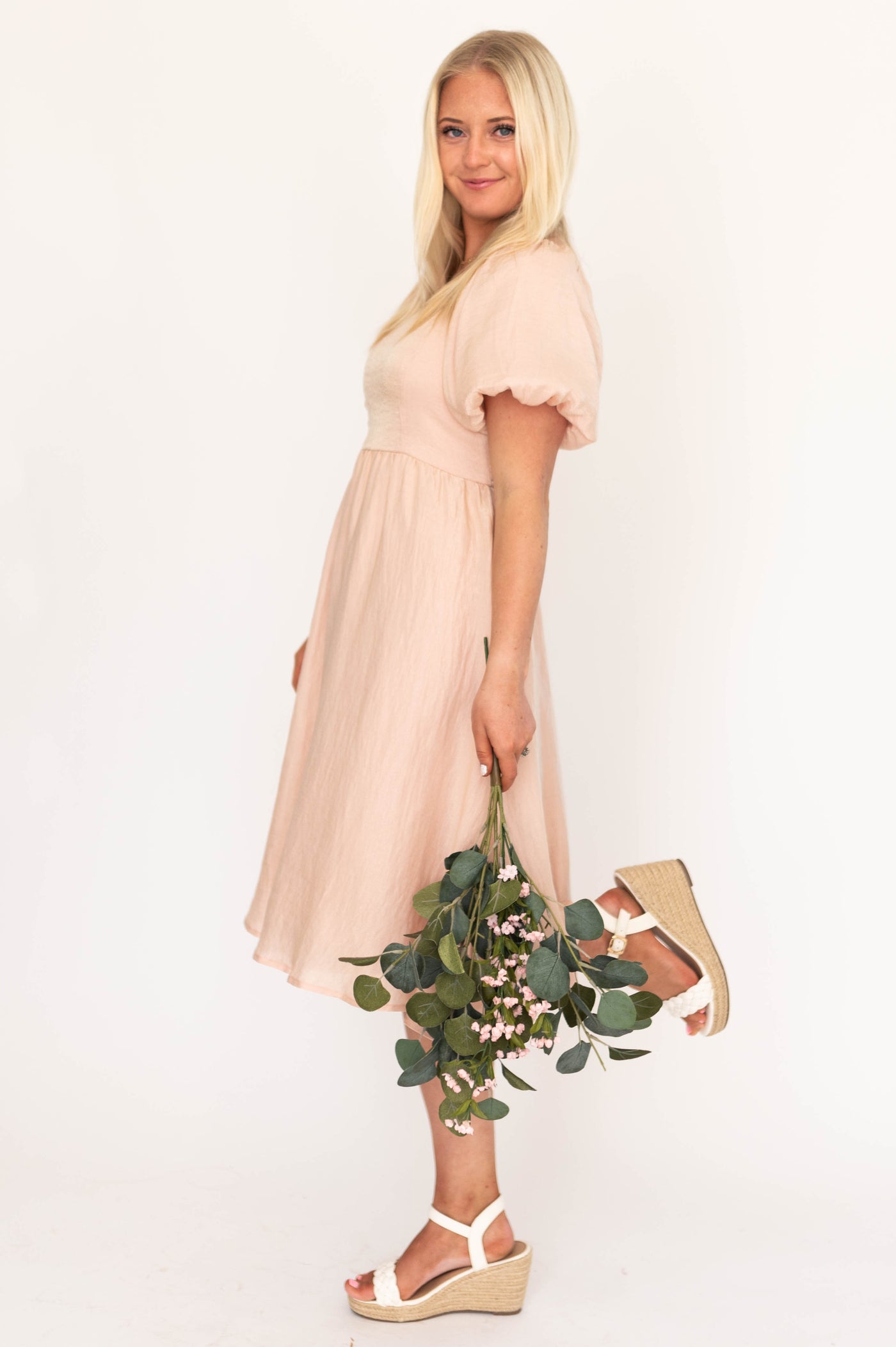 Side view of a blush dress with full short sleeves
