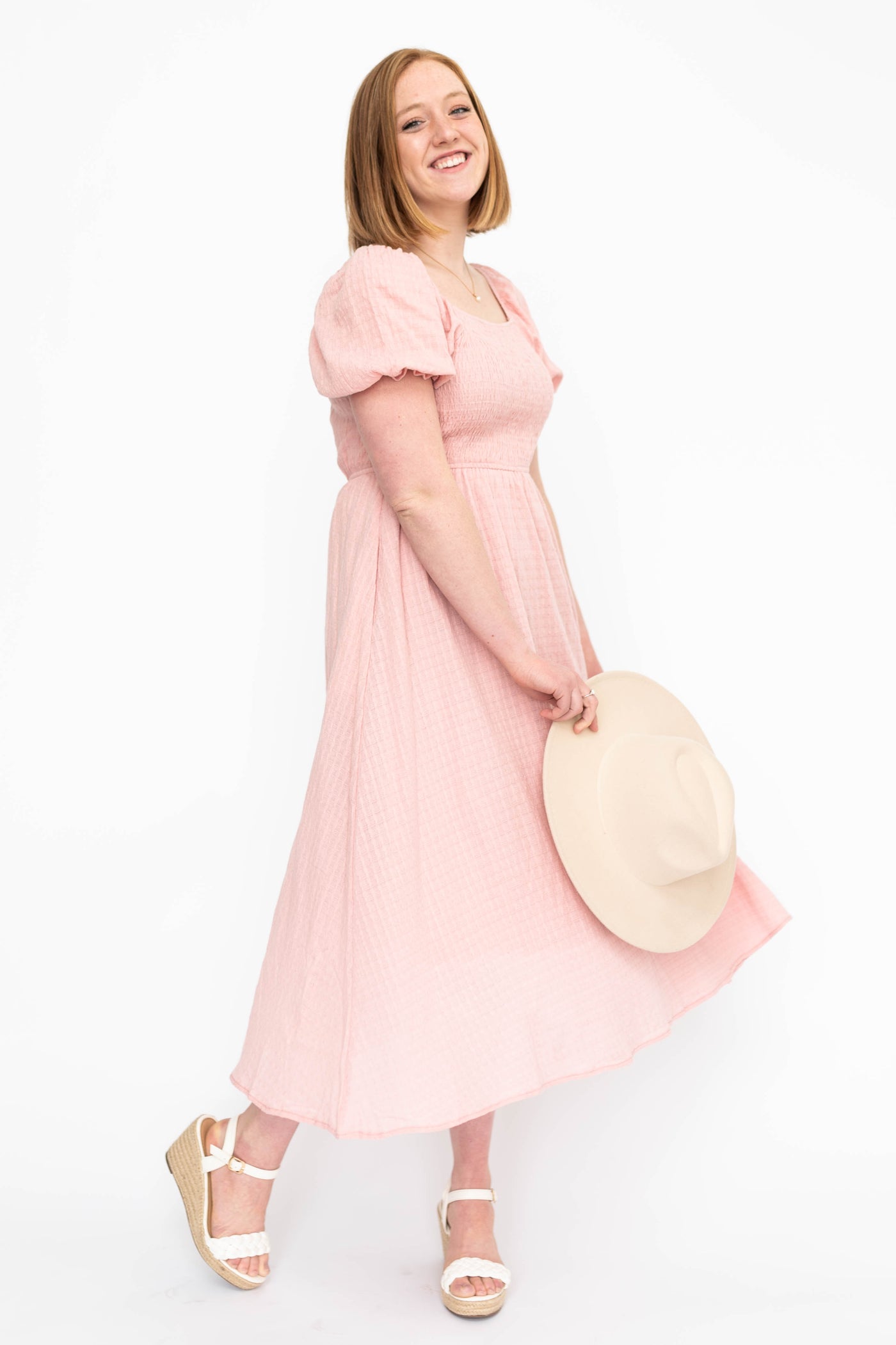 Side view of a mauve dress with pockets and smocked bodice