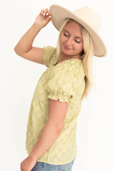 Side view of a short sleeve sage top with elastic on sleeve