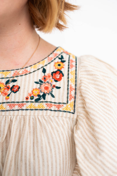 Taupe to with embroidery around the neck