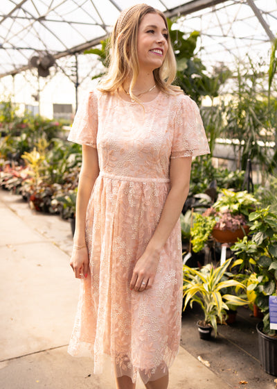 Short sleeve peach floral dress with a band around the waist