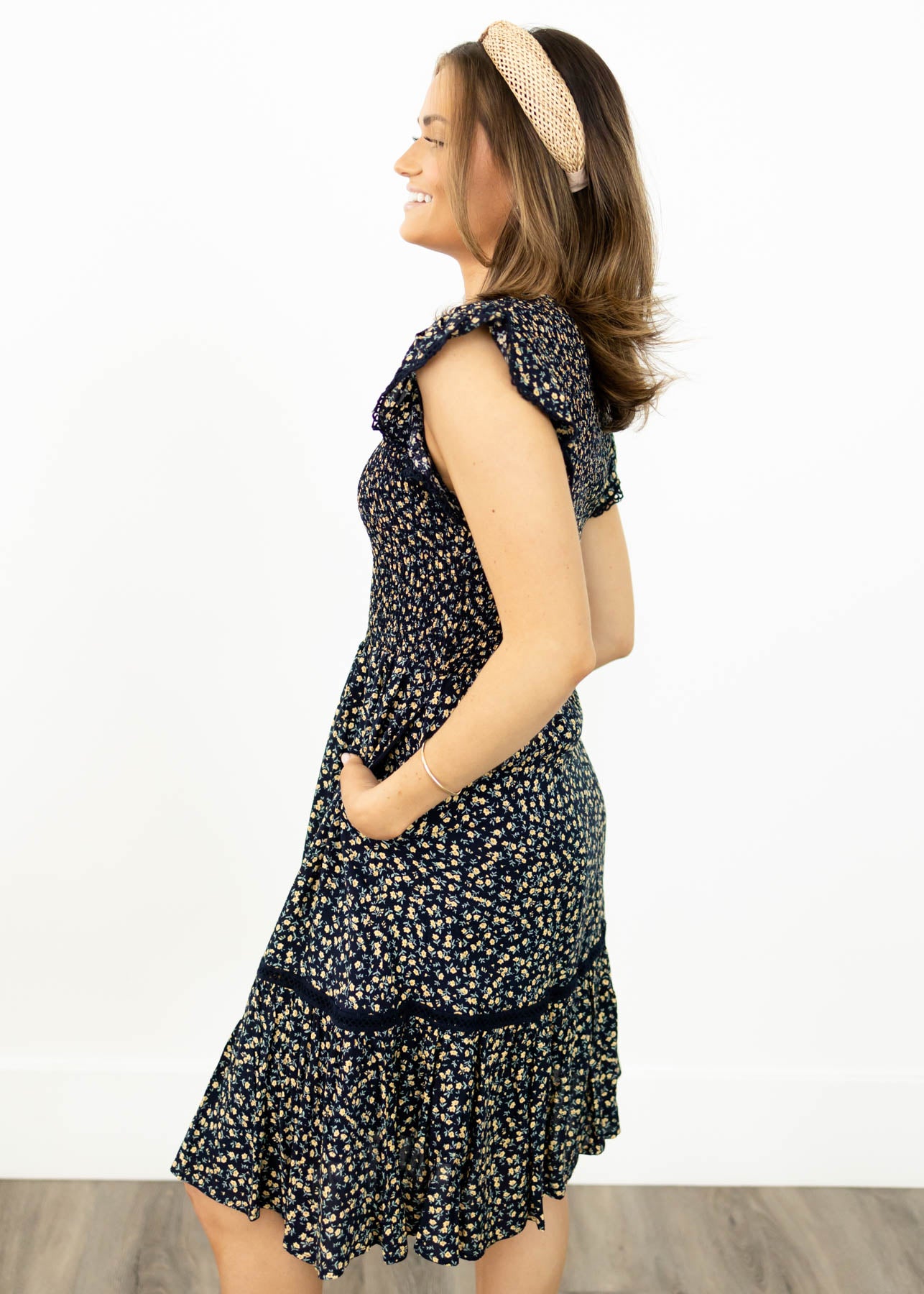 Side view of a navy floral dress with pockets