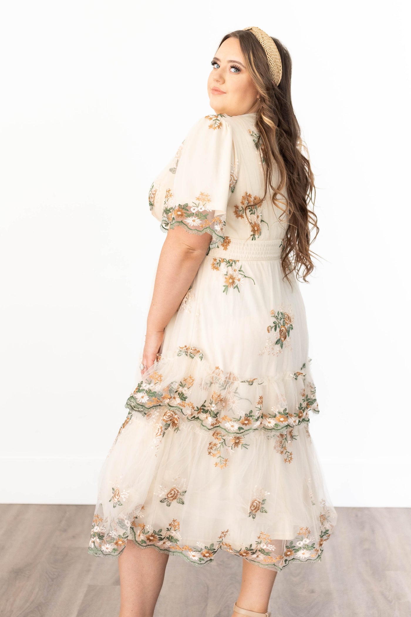 Side view of a plus size flower taupe dress