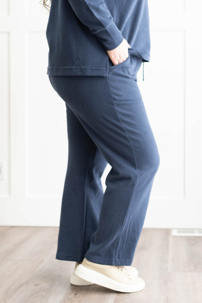 Side view of the pants on a plus size navy set